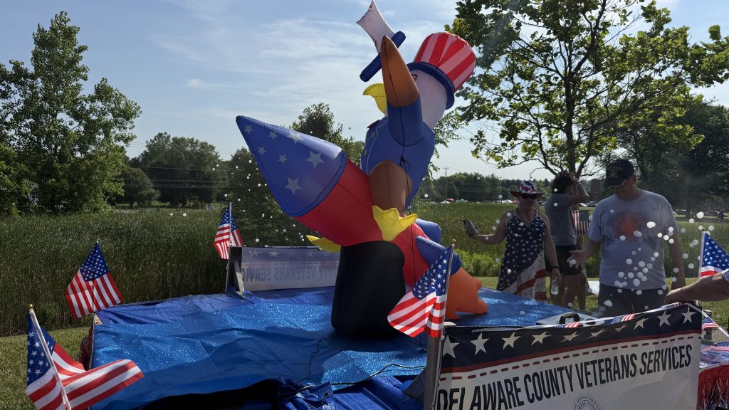 People blow bubbles beside a patriotic eagle on the Veterans Services parade float.